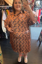 Load image into Gallery viewer, Full-body front view of a size 22W Eva Franco pink, maroon, orange, and green geometric print collared midi dress styled with sneakers on a size 20/22 model.
